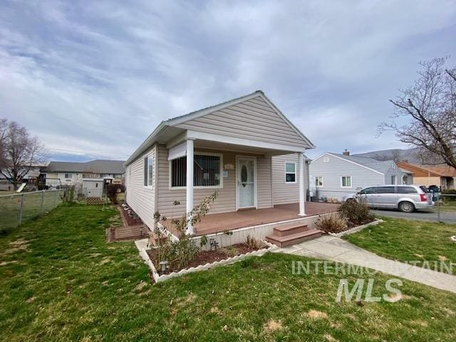 view of front of home with fence and a front lawn