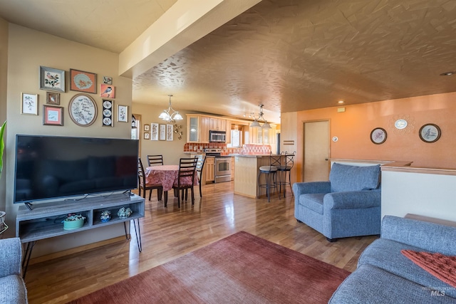 living area with light wood-style floors and an inviting chandelier