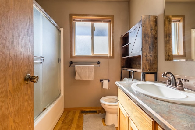 full bathroom with toilet, wood finished floors, vanity, visible vents, and baseboards