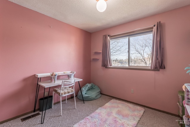 office space with a textured ceiling, carpet floors, visible vents, and baseboards