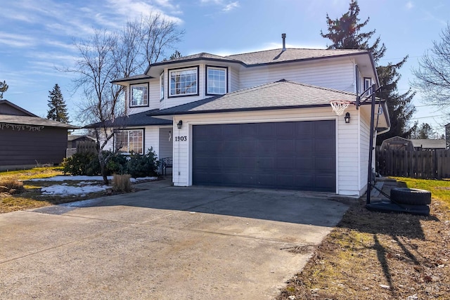 traditional-style house featuring a garage, concrete driveway, fence, and a shingled roof