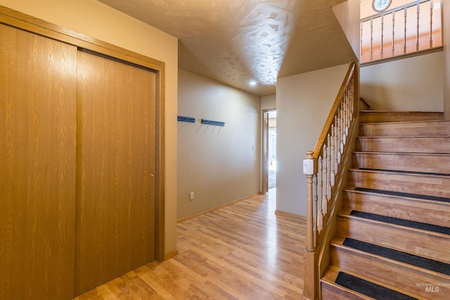 stairway featuring baseboards and wood finished floors