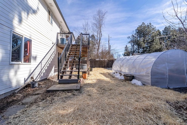 view of yard featuring stairs, an outdoor structure, an exterior structure, and fence