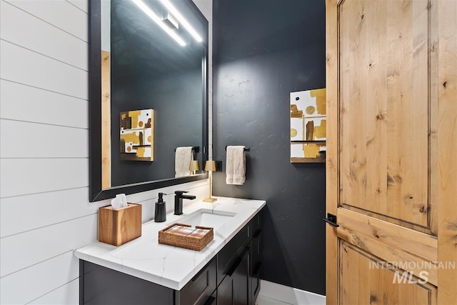 bathroom featuring wood walls and vanity