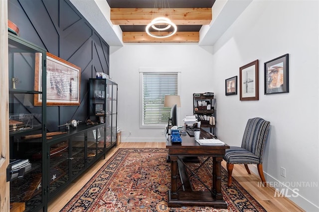 office with hardwood / wood-style flooring and beam ceiling