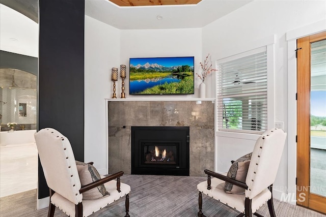 sitting room featuring a tiled fireplace