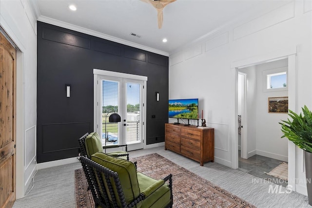 sitting room featuring ornamental molding and ceiling fan