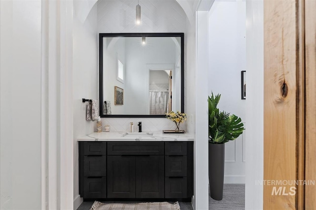 bathroom with backsplash, walk in shower, and vanity