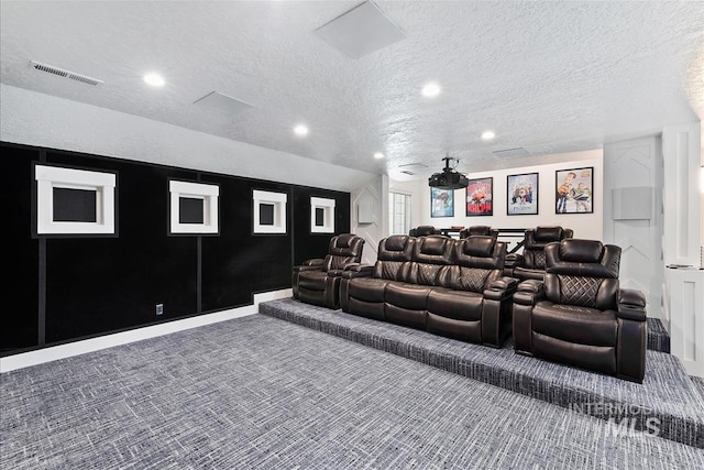 carpeted home theater room with a textured ceiling