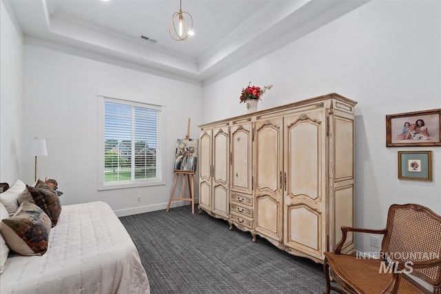 carpeted bedroom featuring ornamental molding and a tray ceiling