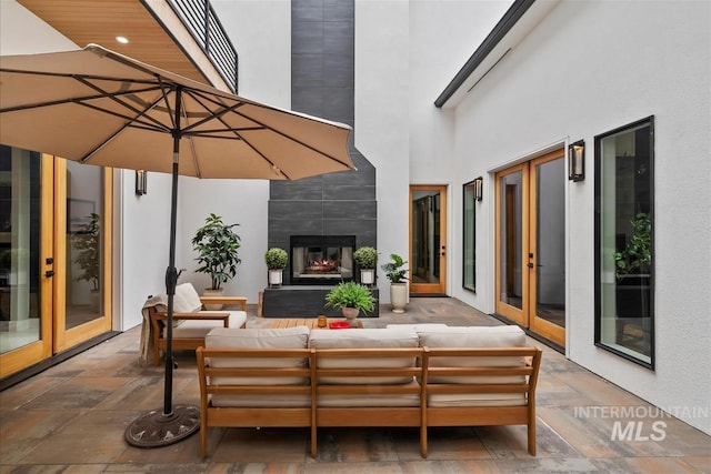 view of patio / terrace with french doors and an outdoor living space with a fireplace