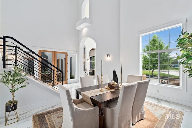 dining area featuring a towering ceiling