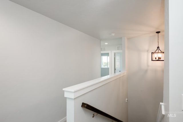 stairway featuring a chandelier, visible vents, and baseboards