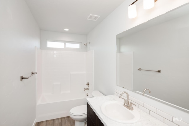 full bath featuring toilet,  shower combination, visible vents, vanity, and wood finished floors