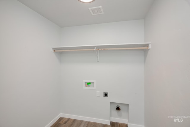 clothes washing area with wood finished floors, laundry area, hookup for an electric dryer, visible vents, and washer hookup