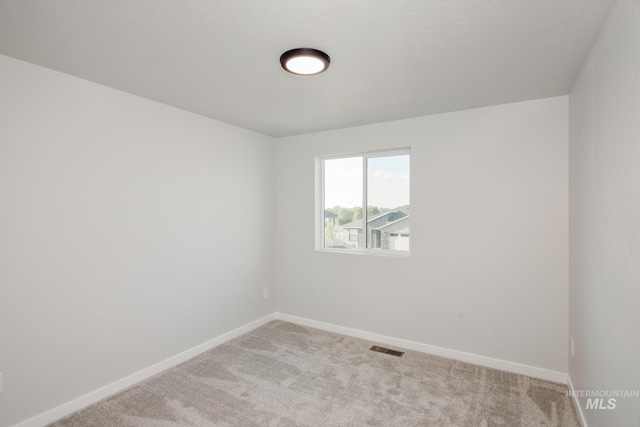 empty room with light carpet, baseboards, and visible vents