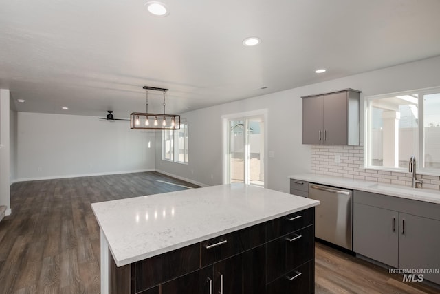 kitchen featuring backsplash, gray cabinetry, a sink, and dishwasher