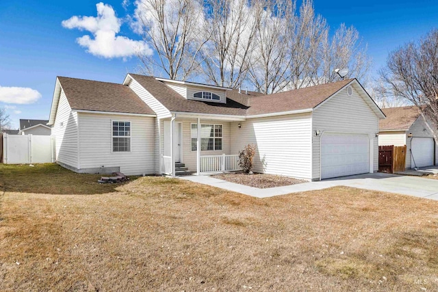 view of front of property featuring a porch, a front lawn, fence, and a garage