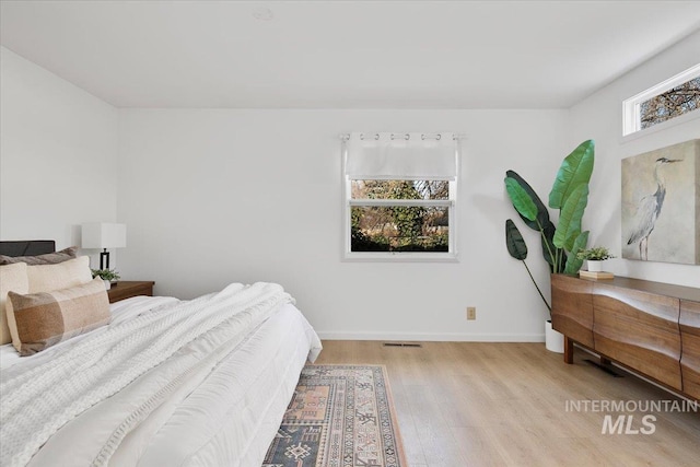 bedroom with wood finished floors and baseboards