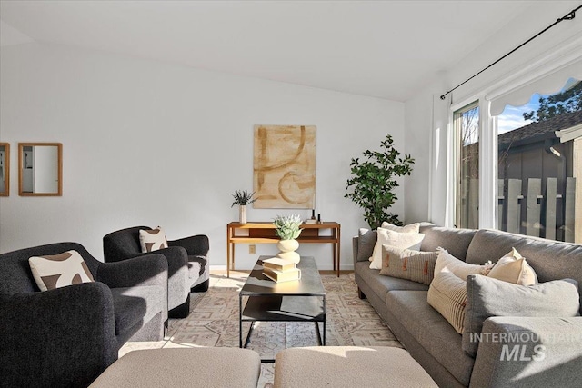 living room with baseboards and vaulted ceiling