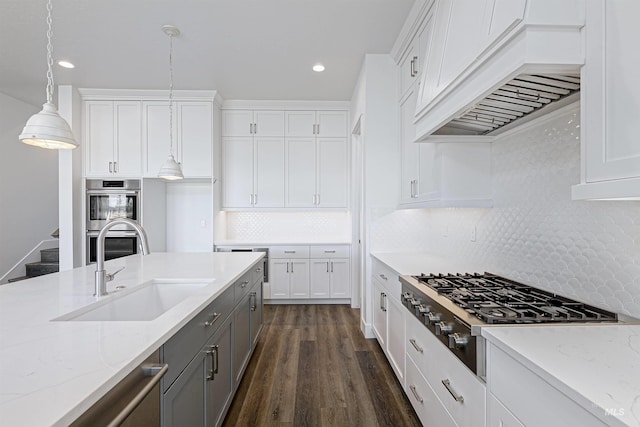 kitchen featuring white cabinets, premium range hood, stainless steel appliances, and hanging light fixtures