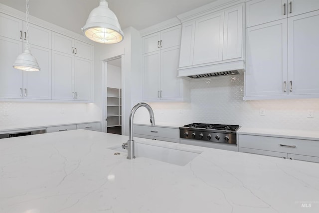 kitchen with white cabinets, light stone countertops, and pendant lighting