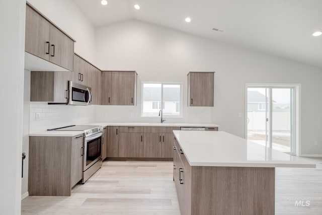 1516 N Coltsfoot Ave, Kuna, ID 83634 - kitchen featuring appliances with stainless steel finishes, lofted ceiling, light countertops, light wood finished floors, and recessed lighting