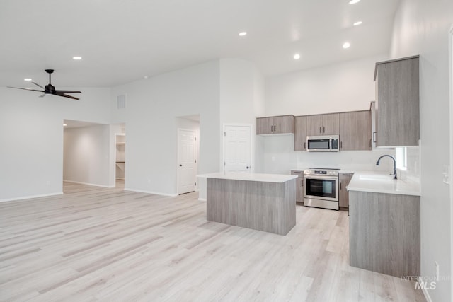1516 N Coltsfoot Ave, Kuna, ID 83634 - kitchen with stainless steel appliances, open floor plan, a kitchen island, high vaulted ceiling, and ceiling fan