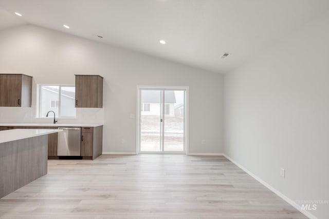 1516 N Coltsfoot Ave, Kuna, ID 83634 - kitchen featuring stainless steel dishwasher, vaulted ceiling, light countertops, light wood-type flooring, and healthy amount of natural light