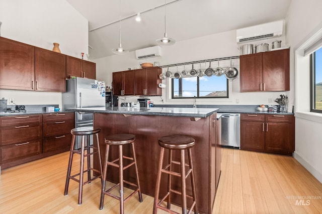 269 N 100 E, Fairfield, ID 83327 - kitchen featuring a wall unit AC, stainless steel appliances, dark countertops, a breakfast bar area, and high vaulted ceiling
