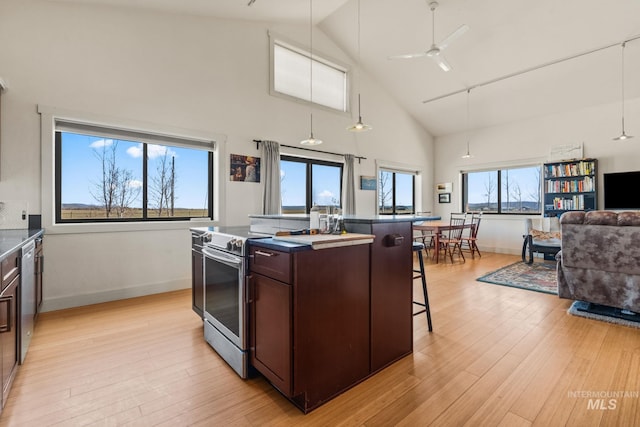 269 N 100 E, Fairfield, ID 83327 - kitchen featuring appliances with stainless steel finishes, dark countertops, a breakfast bar area, dark brown cabinetry, and open floor plan