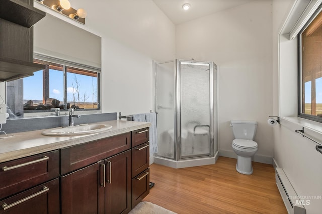 269 N 100 E, Fairfield, ID 83327 - full bathroom with a baseboard radiator, toilet, a shower stall, vanity, and wood finished floors