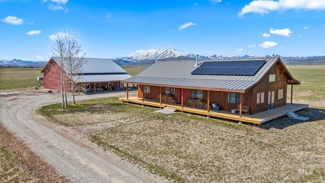 269 N 100 E, Fairfield, ID 83327 - rear view of house featuring dirt driveway, a mountain view, solar panels, and metal roof