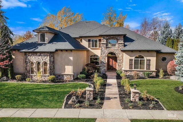 view of front of home featuring a balcony and a front lawn