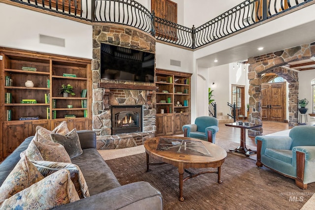 living room with a fireplace and a high ceiling