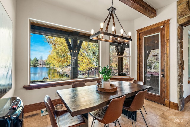 tiled dining space with a water view, a notable chandelier, and beamed ceiling