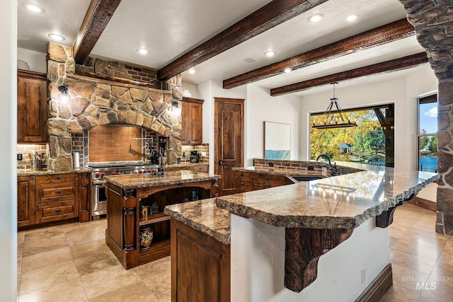 kitchen with beam ceiling, backsplash, a large island, sink, and double oven range