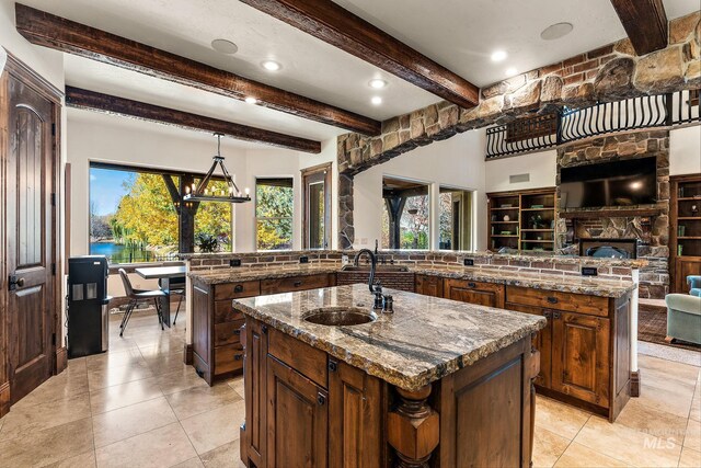 kitchen with sink, an island with sink, and a healthy amount of sunlight