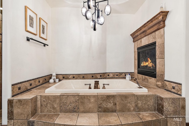 bathroom featuring a tiled fireplace and a relaxing tiled tub