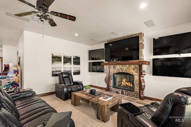 carpeted living room featuring ceiling fan and a fireplace