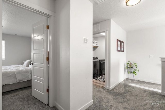 hallway featuring a textured ceiling and dark carpet