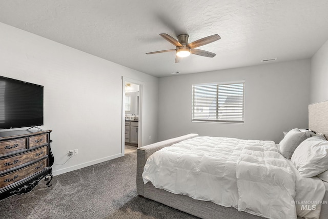 bedroom featuring ensuite bath, a textured ceiling, dark colored carpet, and ceiling fan