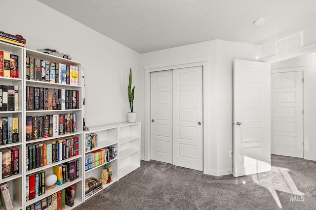 interior space with a closet and dark colored carpet