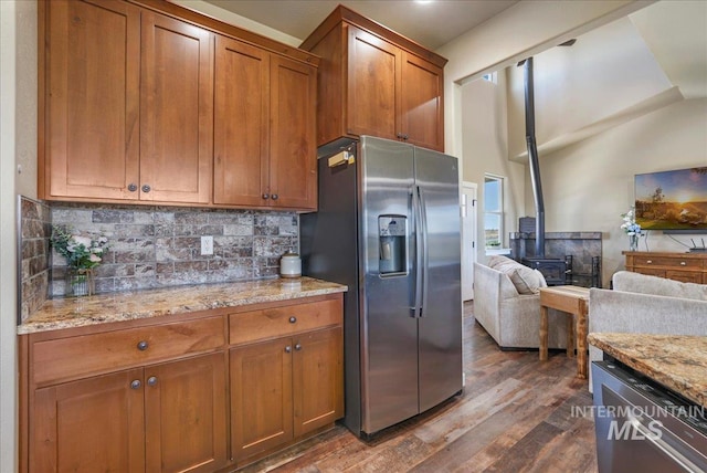 628 Pioneer Mountain Loop, Jerome, ID 83338 - kitchen featuring stainless steel appliances, a wood stove, dark wood finished floors, brown cabinetry, and decorative backsplash