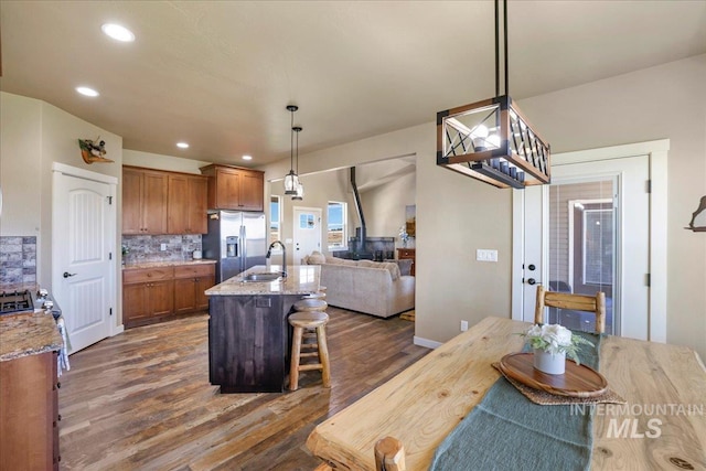 628 Pioneer Mountain Loop, Jerome, ID 83338 - kitchen featuring stainless steel refrigerator with ice dispenser, brown cabinets, dark wood-style floors, tasteful backsplash, and a sink
