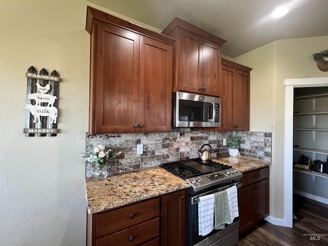 628 Pioneer Mountain Loop, Jerome, ID 83338 - kitchen with appliances with stainless steel finishes, tasteful backsplash, light stone countertops, dark wood-style flooring, and baseboards