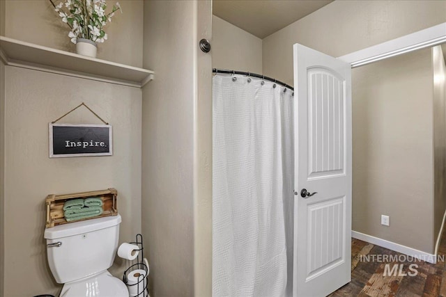 628 Pioneer Mountain Loop, Jerome, ID 83338 - bathroom featuring toilet, wood finished floors, baseboards, and a shower with curtain
