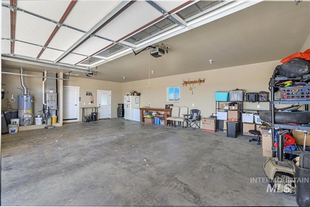 628 Pioneer Mountain Loop, Jerome, ID 83338 - garage featuring a garage door opener, water heater, and freestanding refrigerator