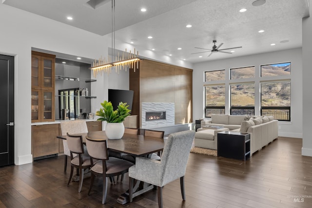 dining area with dark wood finished floors, a fireplace, recessed lighting, and ceiling fan