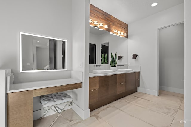 full bathroom with double vanity, baseboards, a sink, and recessed lighting